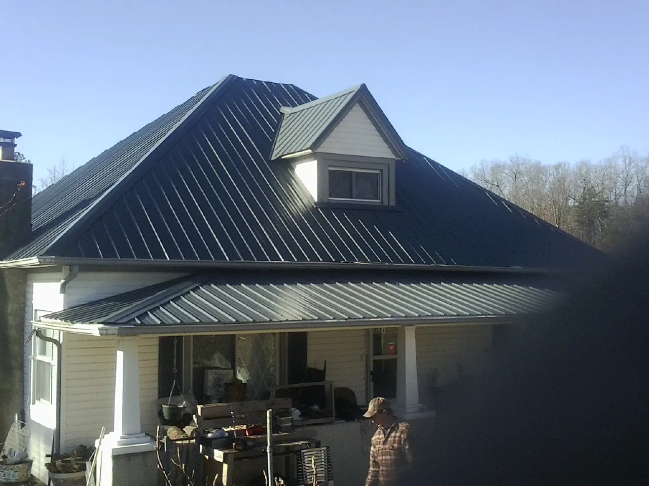 Dark blue standing seam metal roof with a dormer above a front porch in Statesville