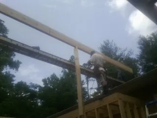 Carpenter setting a ridge beam over a new addition frame — Ice Dam Removal by Roofing Brothers in Statesville