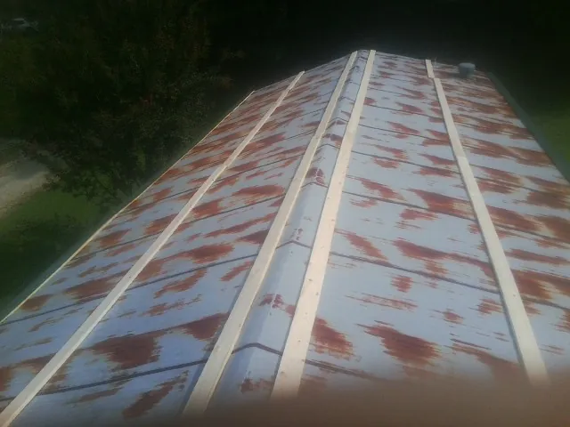 Rusted metal roof panels with new wood purlins before replacement — Storm Damage Roof Repair in Statesville by Roofing Brothers