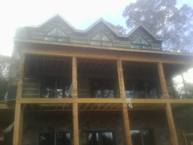 Dormers and porch framing on a large log home under construction — Roof Coating work by our crew in Statesville
