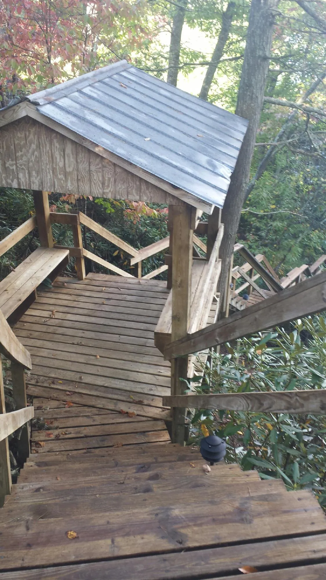 Metal roofed shelter over wooden steps on a wooded walkway — Skylight Repair & Installation work by our crew in Statesville