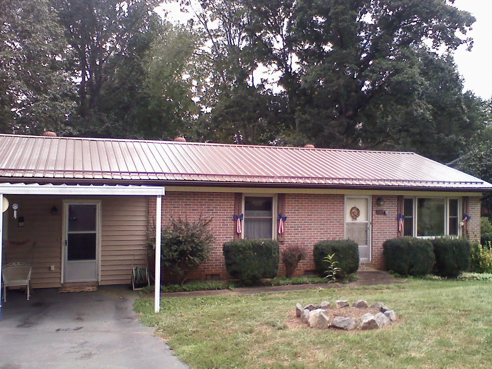 Bronze metal roof and carport on a brick ranch home — Roof Repair work by our crew in Statesville