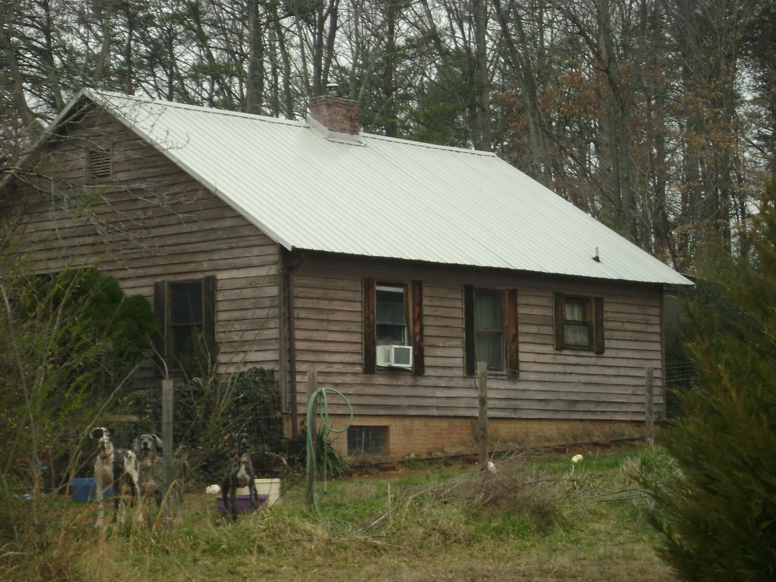 White metal roof on an old wood sided farmhouse, from a Metal Roof Installation job in Statesville